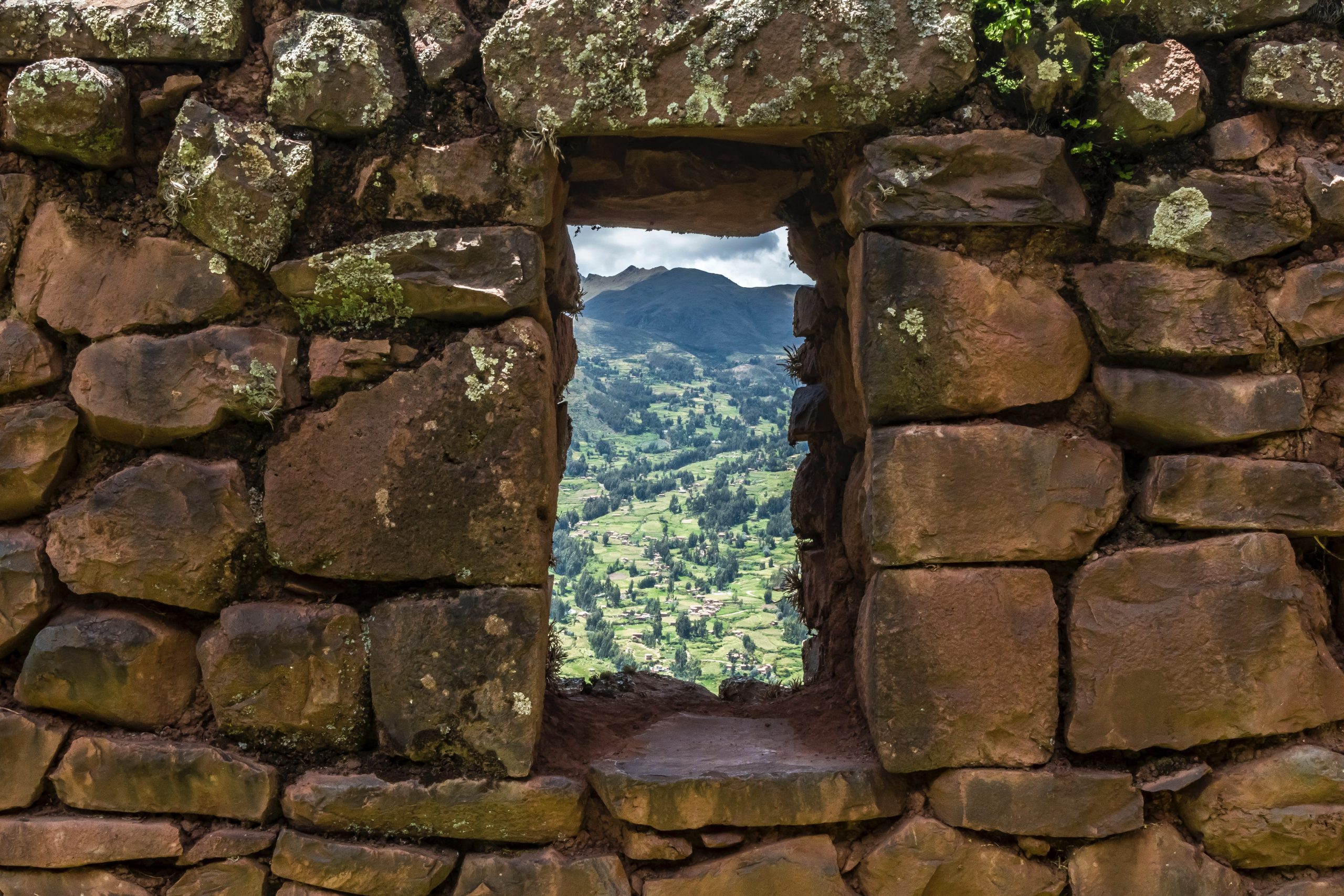 a stone wall with a window opening in the middle